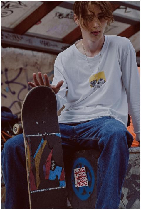 Close-up of a skateboarder in casual wear sitting
