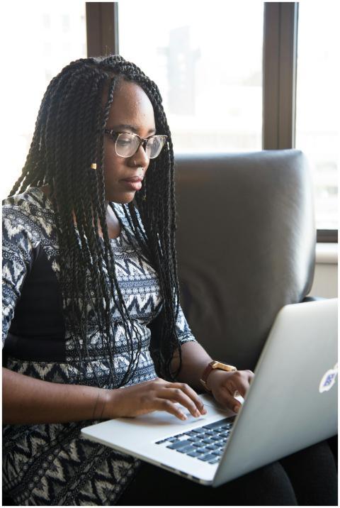 Focused young woman typing on laptop in a contempo