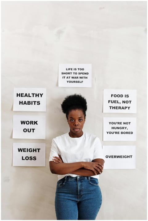 A woman stands in front of health messages promoti