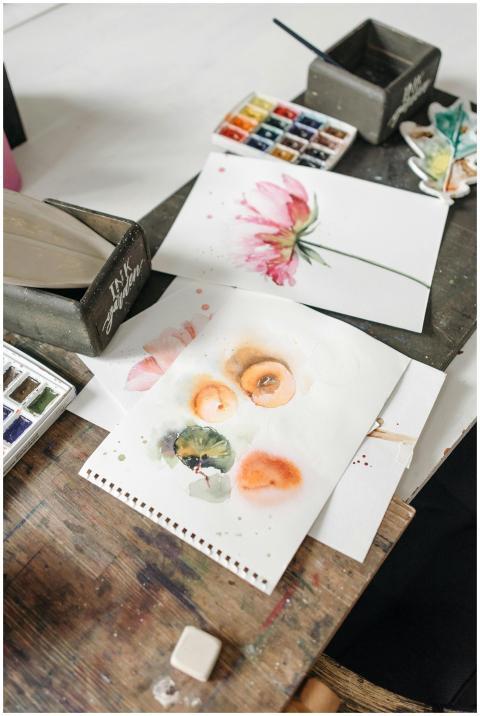 Artistic workspace featuring watercolor paintings