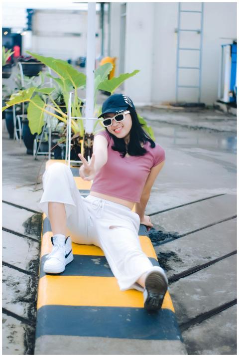 Woman in a pink top and cap posing outdoors in Cim