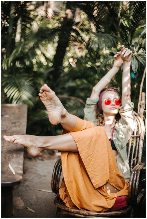 A woman in colorful attire relaxes outdoors, stret