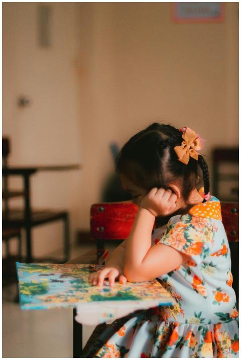 A young girl engrossed in reading a book in an ind