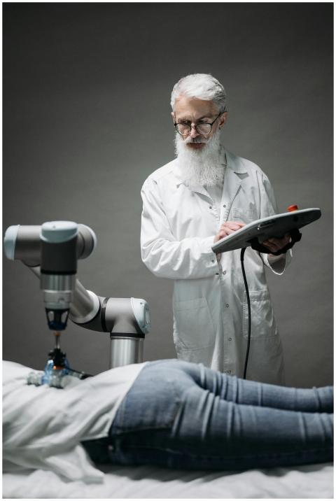 A senior scientist controls a robotic arm for medi