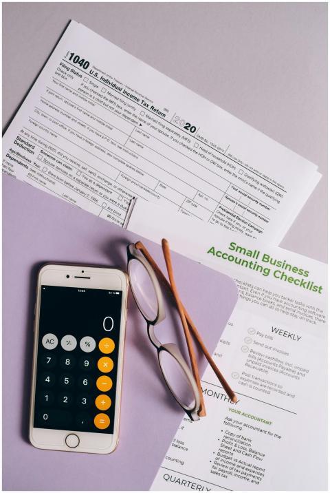 Flat lay of tax forms, checklist, smartphone, and