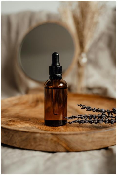 Amber glass dropper bottle on a wooden tray with l