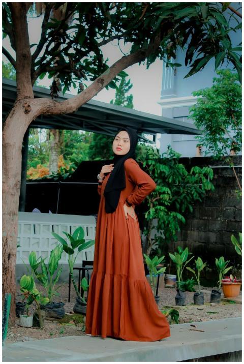 Young woman posing in a long dress outdoors in Kot