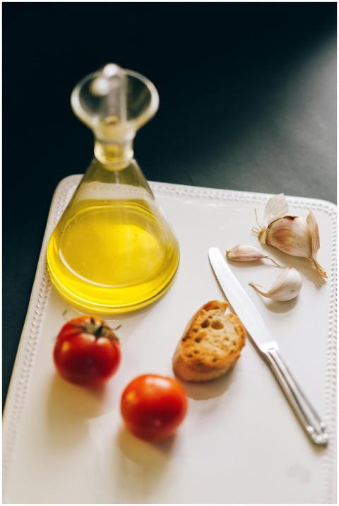 Fresh tomatoes, garlic, and olive oil on a white t