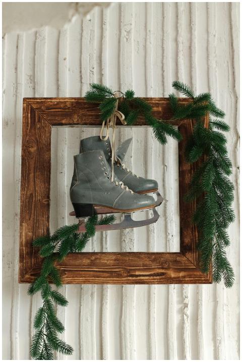 Old ice skates in wooden frame with fir branches o