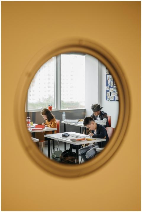 Three children concentrating on assignments in a c