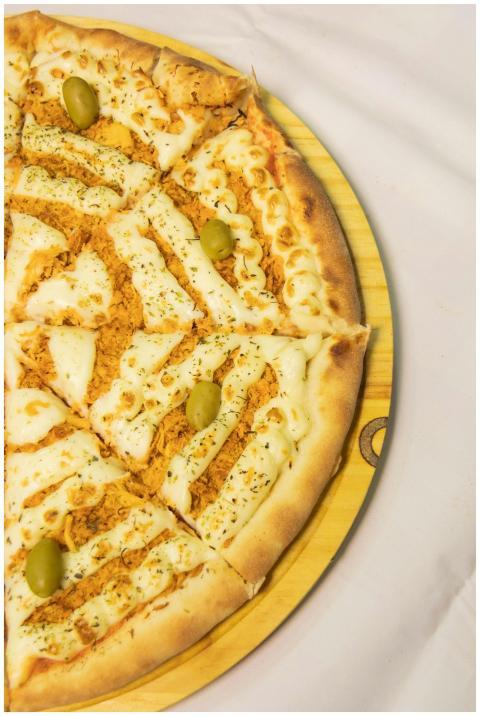 Hot and freshly baked pizza garnished with cheese