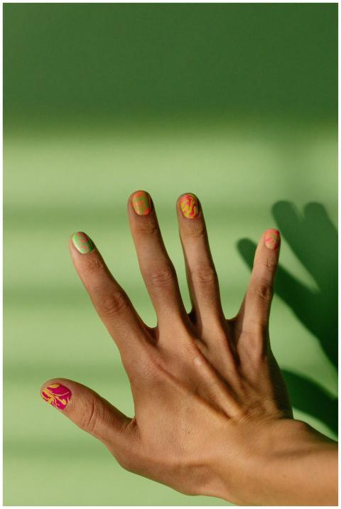 Close-up of a hand with colorful nail art against