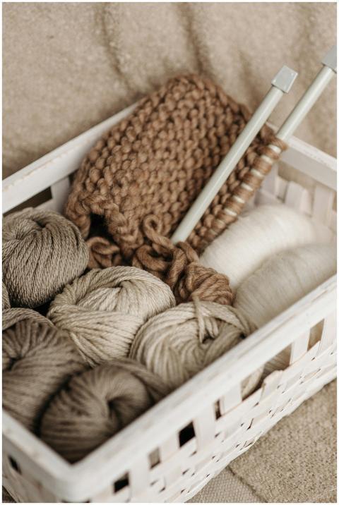 A rustic basket filled with wool yarn and knitting