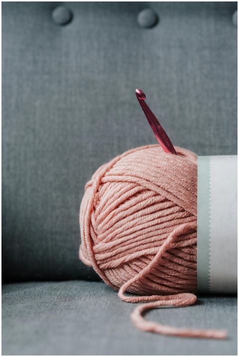 Ball of soft yarn for knitting with pink crochet h