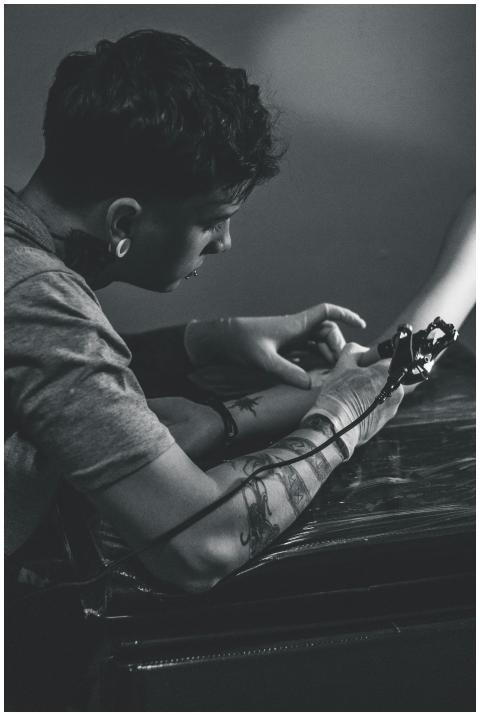 A tattoo artist working meticulously on a client's