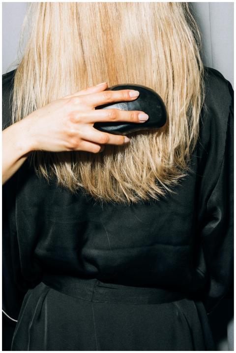 Close-up of a person brushing their long blonde ha