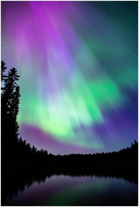 Stunning aurora borealis reflecting over a lake in