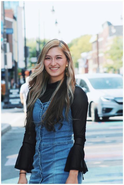Casually dressed woman smiles on a lively street i