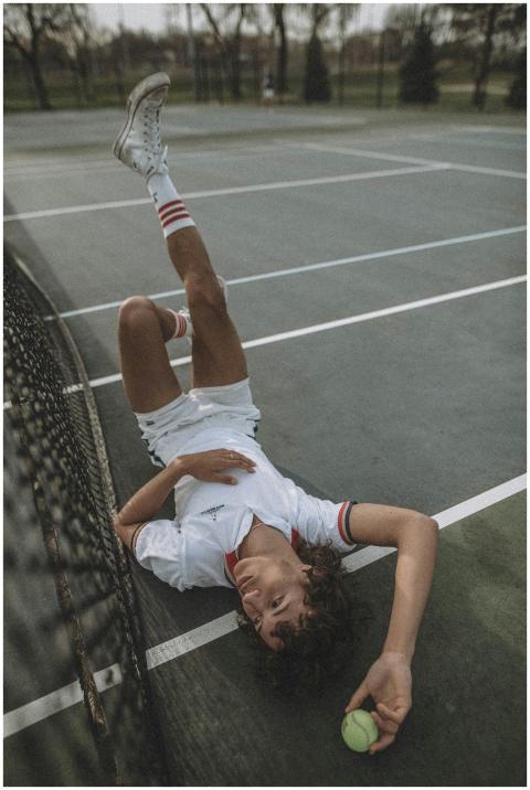 Teen tennis player in casual pose on outdoor court