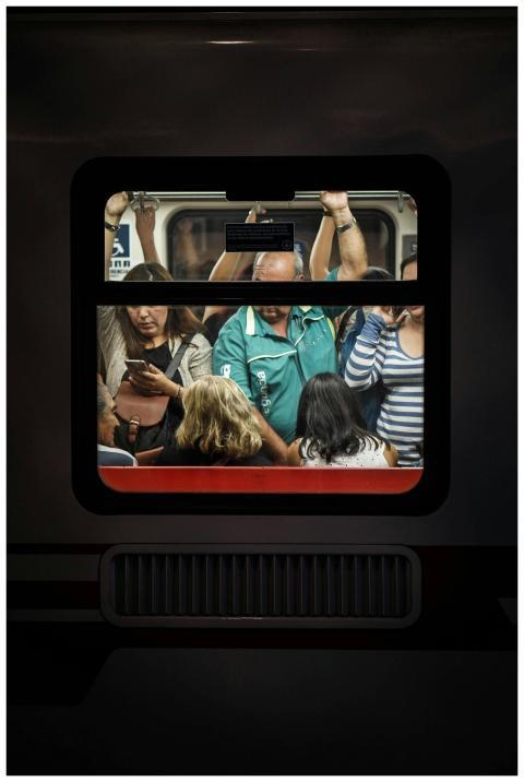 View through a train window revealing crowded comm