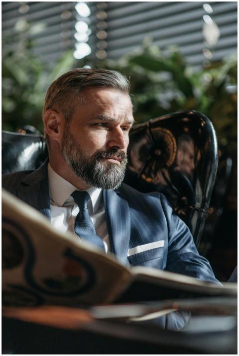 Professional businessman with beard reads a newspa