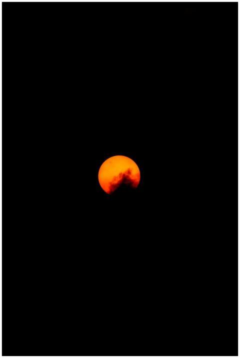 Captivating view of the orange moon setting in the