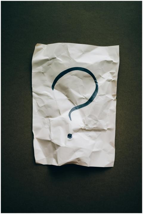 A crumpled sheet with a large black question mark