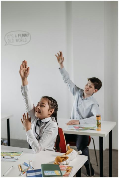 Two children eagerly participate by raising their