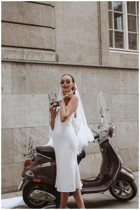 Stylish bride in wedding dress poses with vintage