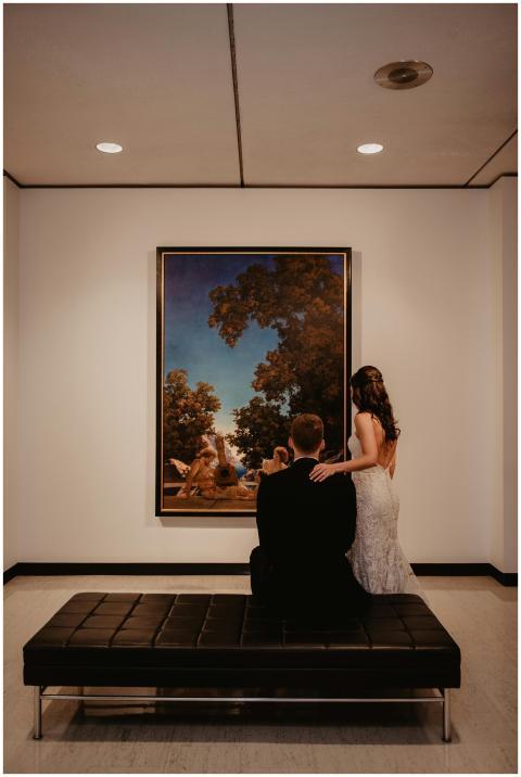 Elegant couple viewing a painting in a modern muse