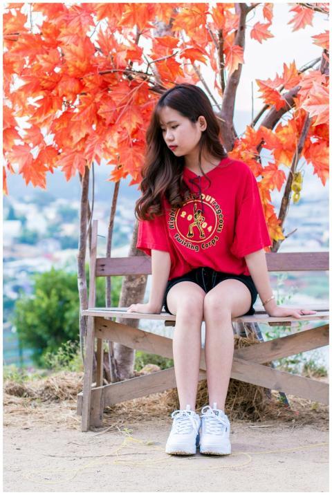 A young woman sits thoughtfully on a bench with vi