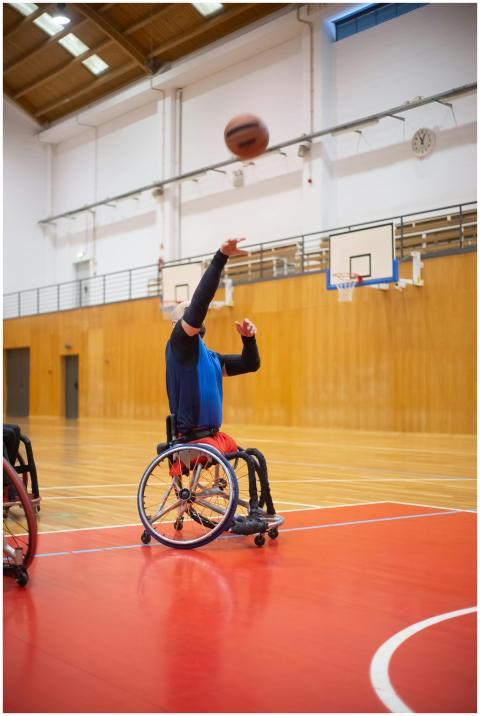 An athlete in a wheelchair playing basketball indo