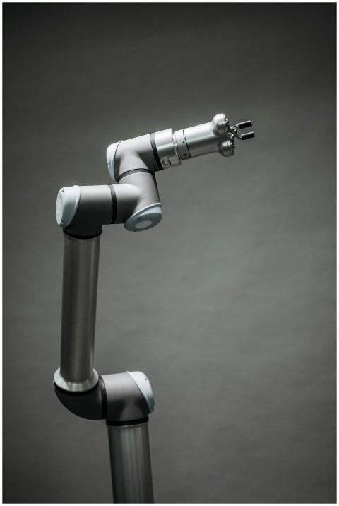An industrial robotic arm on a neutral background,