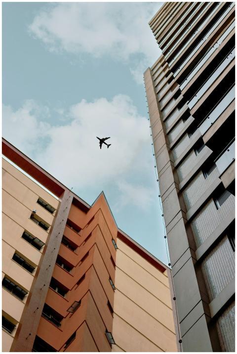 View of skyscrapers with a plane flying above agai