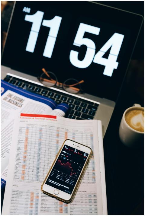 Smartphone displaying stock data on documents with
