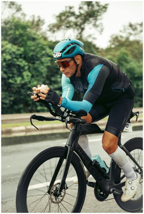 A male cyclist in racing gear intensely riding a b