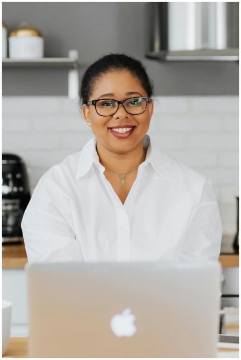 A happy woman in a white shirt and glasses working