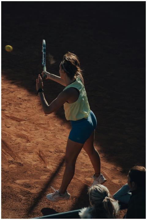 A woman hitting a tennis ball with a racket during