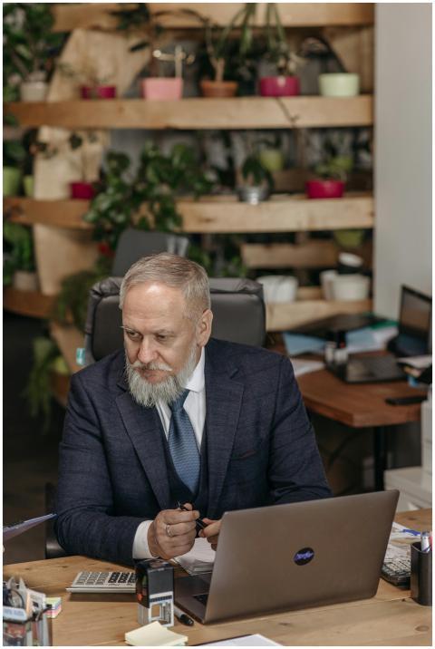 Elderly professional in a formal suit working at a
