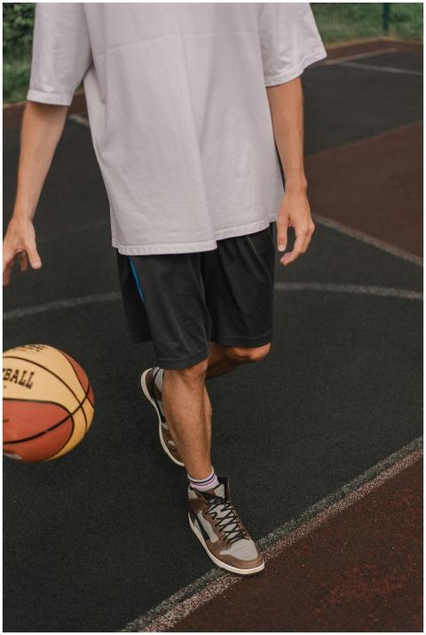 Adult man dribbles a basketball on an outdoor cour