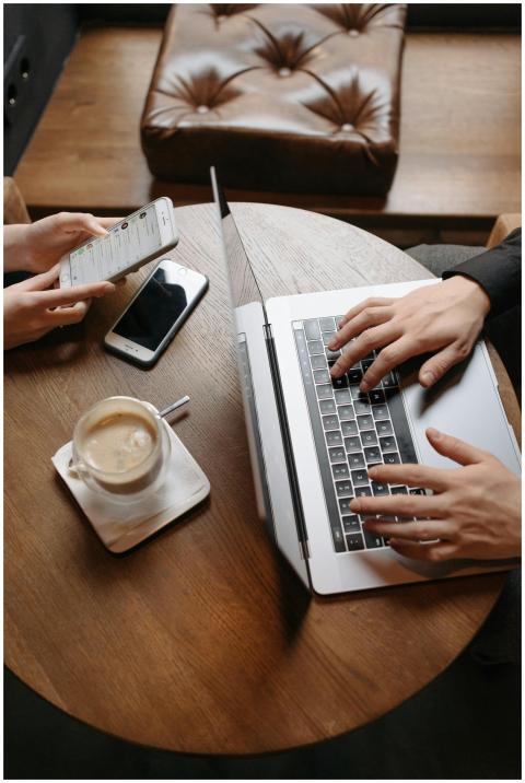 Two people working together in a cafe, using a lap