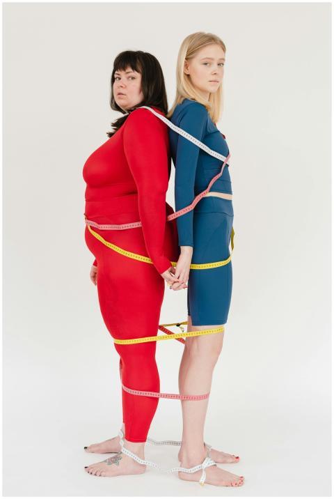 Women in colorful activewear with measuring tapes,