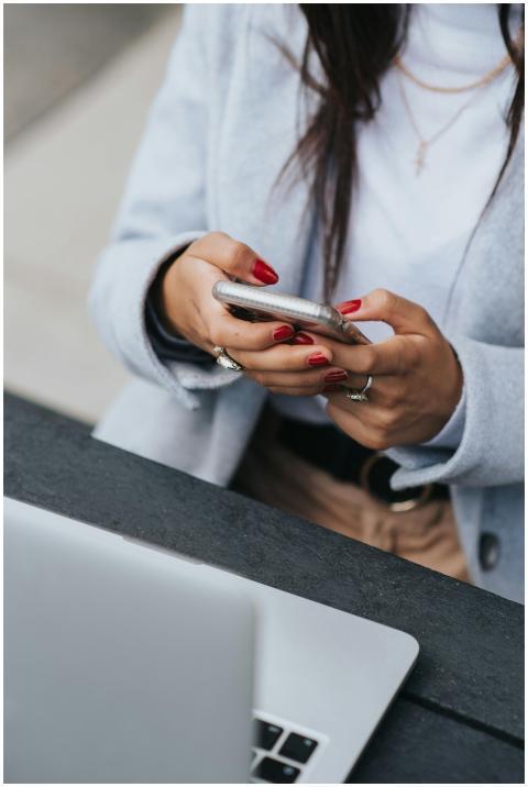 A businesswoman with red nails using a smartphone