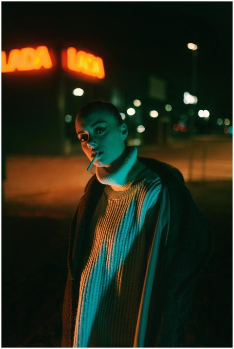 Moody nighttime fashion shot of a woman in a city
