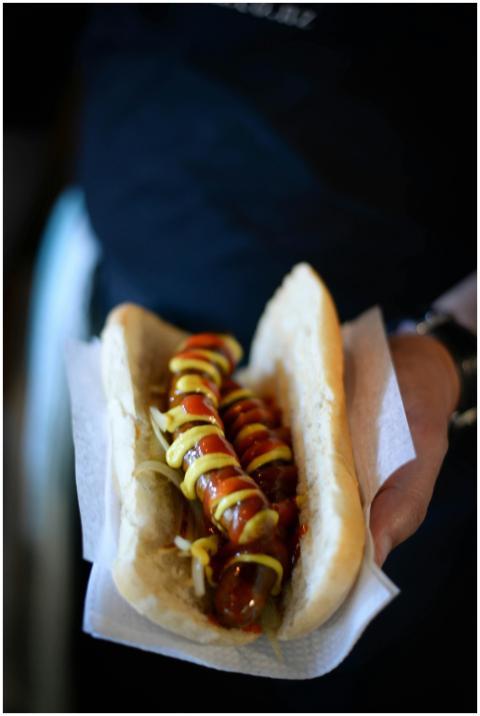 High angle of crop anonymous person with hot dog w