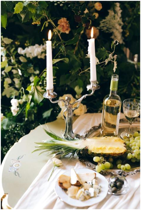 Luxurious table setup with candles, wine, cheese,
