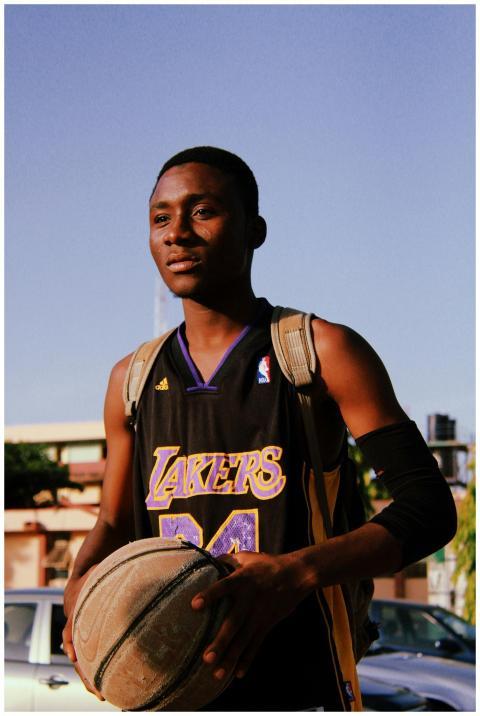 A confident young basketball player holding a ball