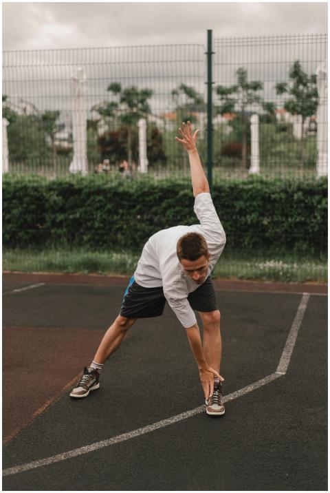 A man performs stretching exercises on an outdoor