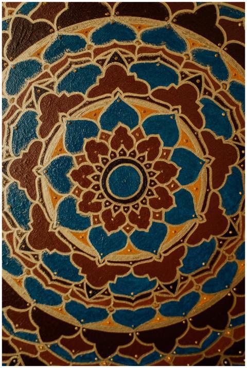 Detailed close-up of a mandala artwork with blue,