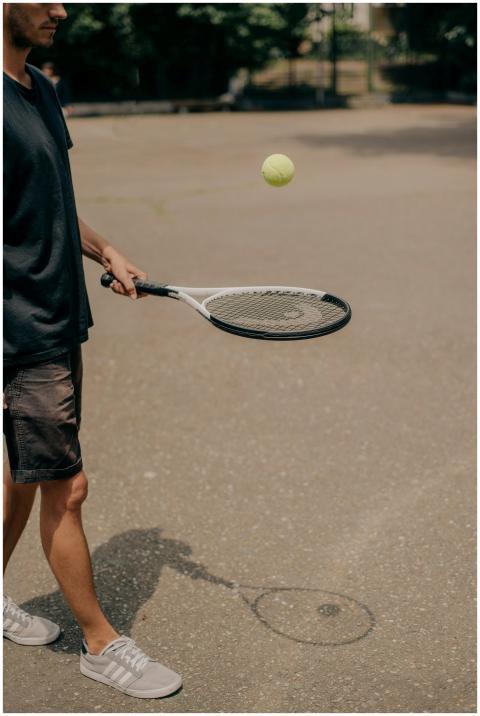 A person training outdoors with a tennis racket an